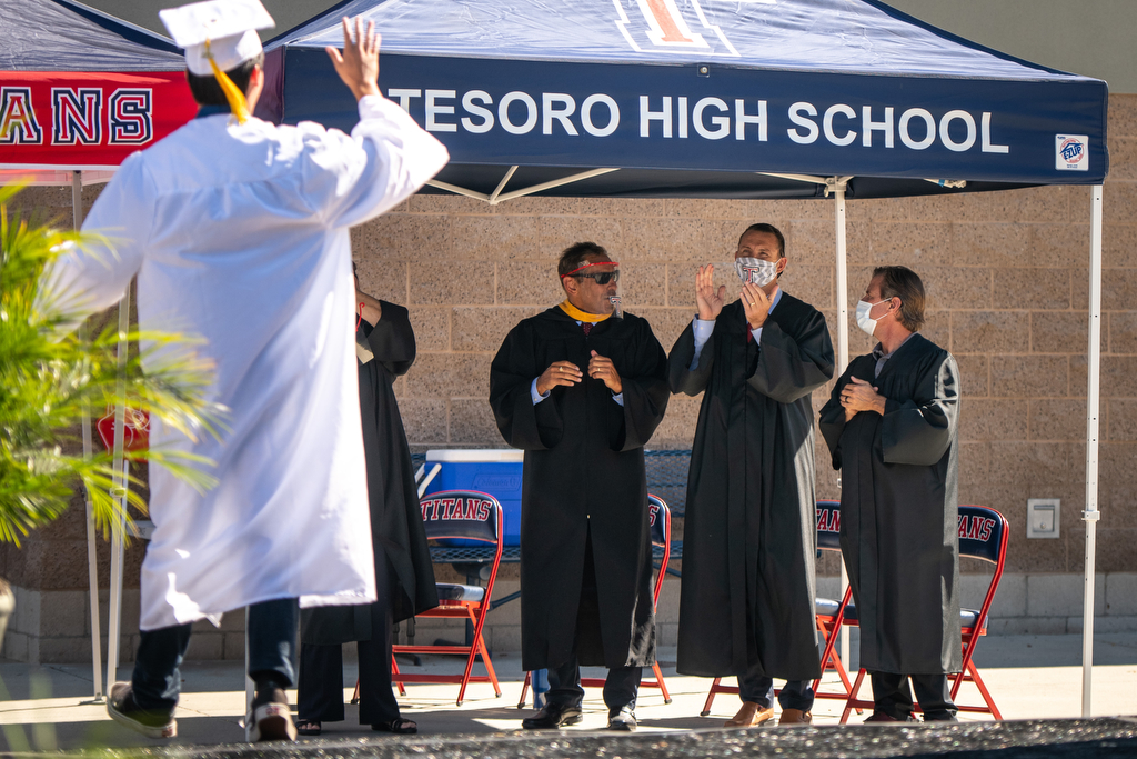 A Tesoro High School student waves as school officials applaud and congratulate the graduate during the graduation ceremony held July 24, 2020. Photo by Chris Brocoff/Cornerstone Communications 